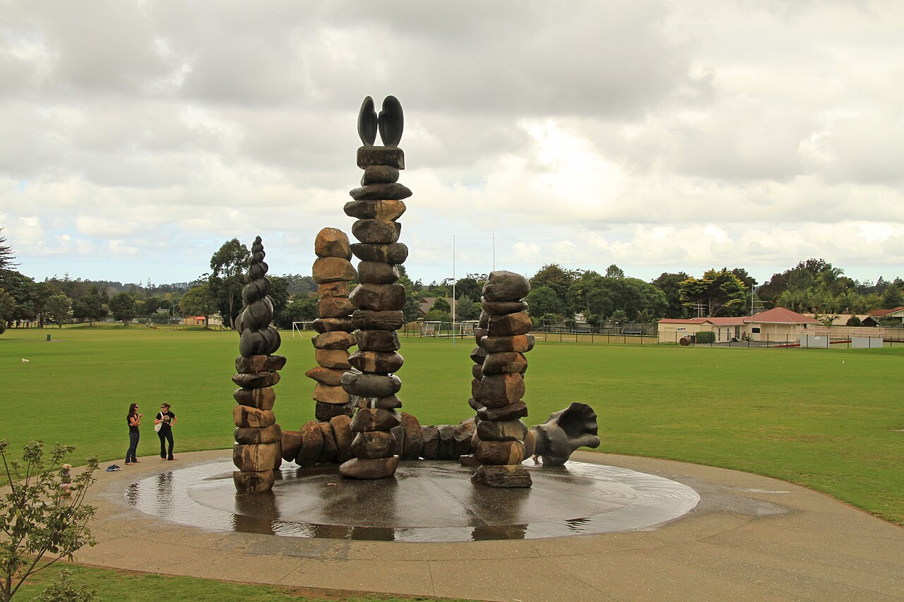 Stacked stone columns of varying shapes rising from a circular water basin in Kerikeri Domain.