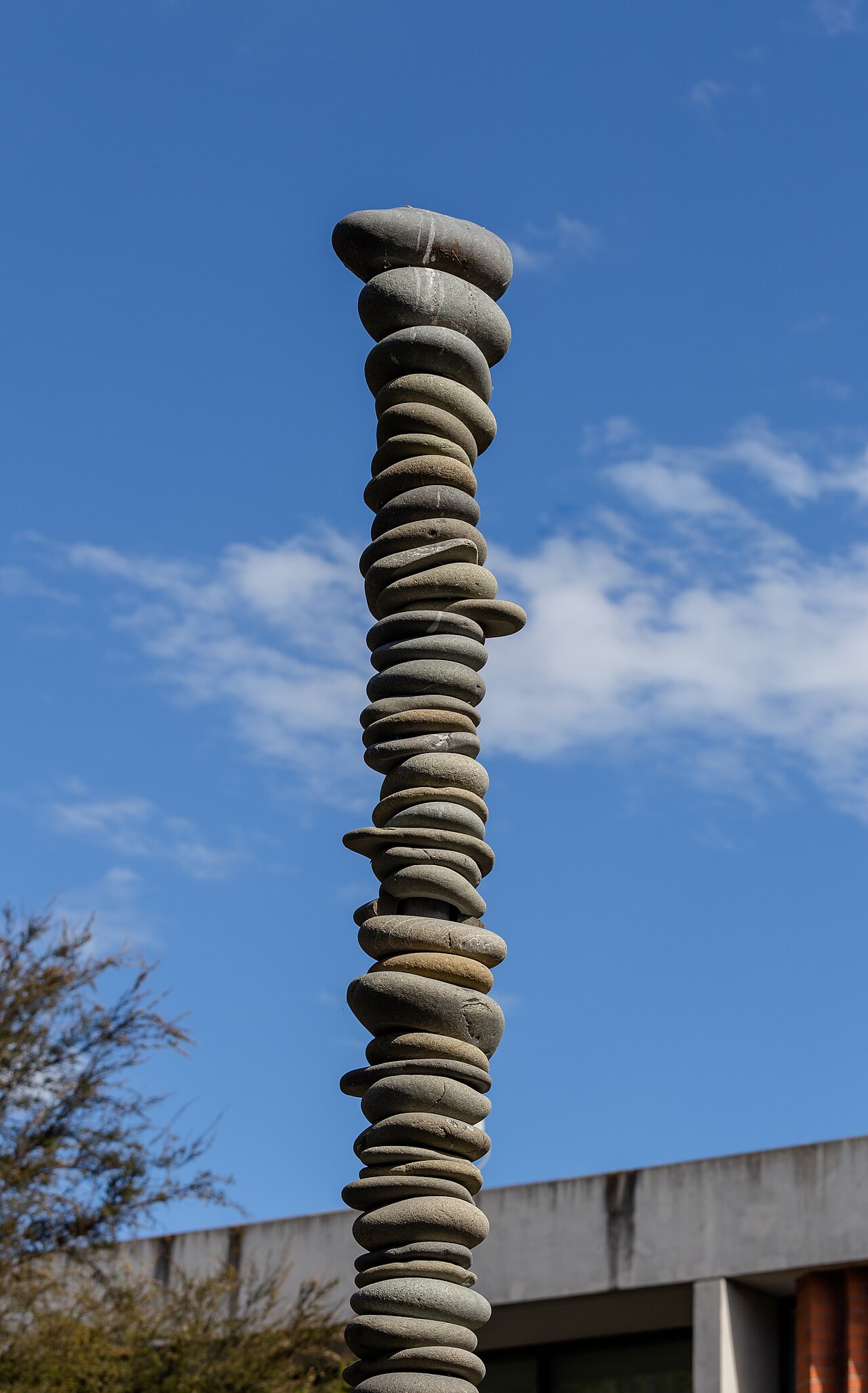 A tall column of closely stacked flat stones against a blue sky on the Lincoln University campus.