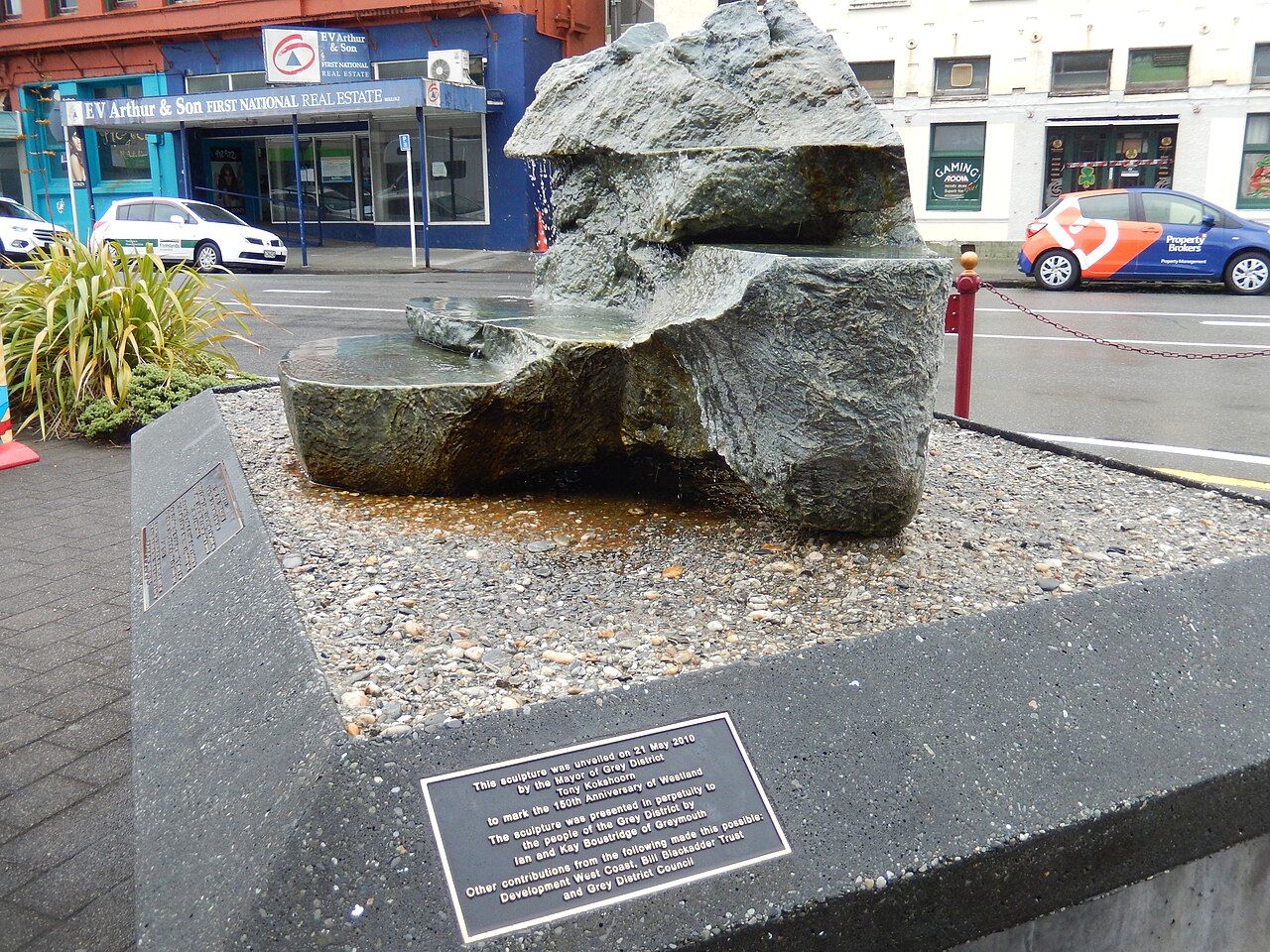 Side view of the carved pounamu water sculpture and its permanent dedication plaque in Greymouth.