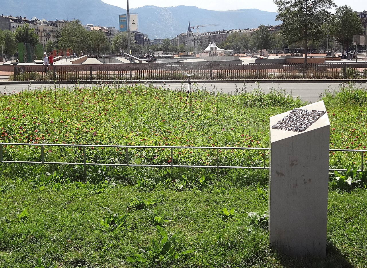 The reverse of Vincent Du Bois’s marble memorial in Geneva, with its commemorative inscription and the Plainpalais setting beyond.